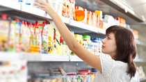 Woman in a grocery aisle picking out baby food 